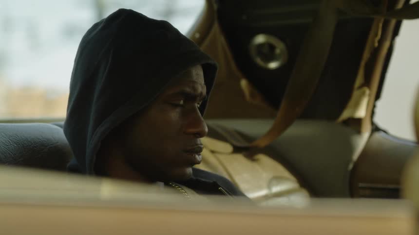 Man sits in the back seat of a car