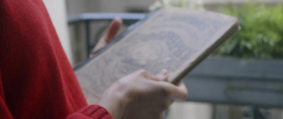 Woman reads on an apartment balcony
