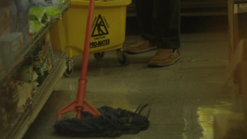 Person mops the floor with a mop and bucket