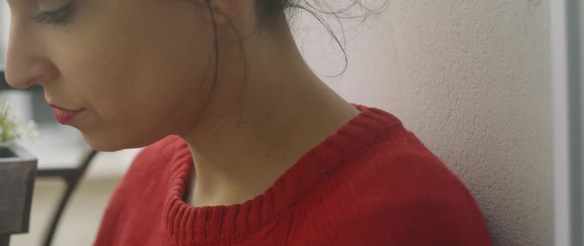 A woman is sitting by the window reading