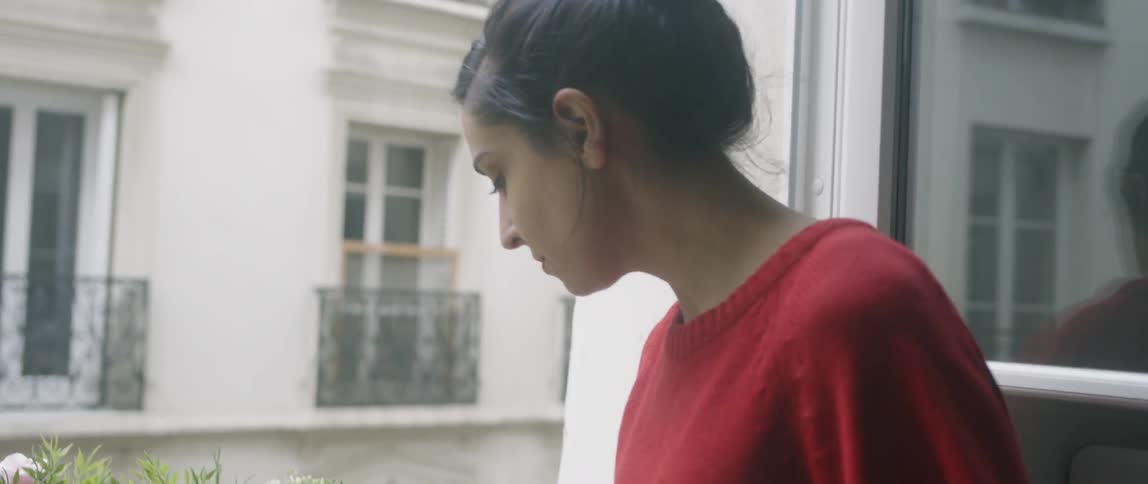 Woman sits by window reading old book