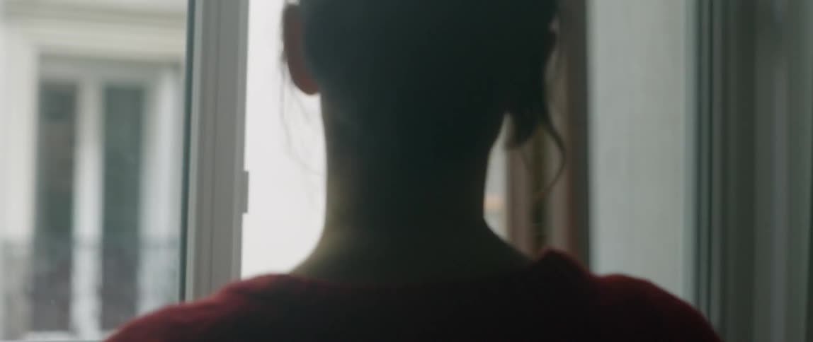 A woman opens an apartment window