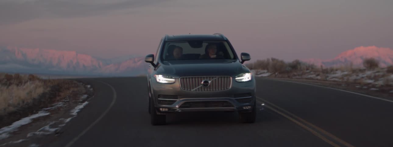 The vehicle turns around the road at sunset