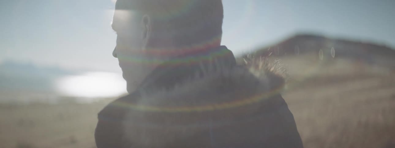 A man stands on the very windy field