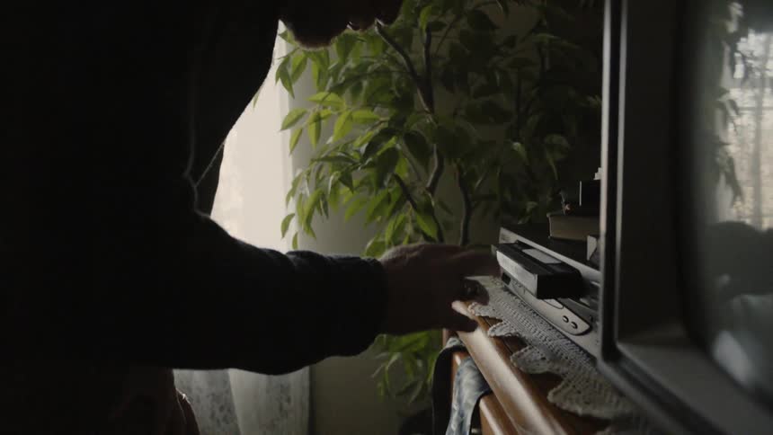 Man puts a vcr into a vcr player