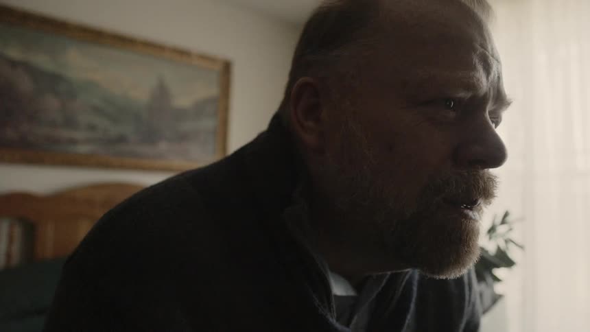 A man leans forward watching something