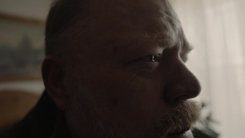 Man cries while sitting on a bed