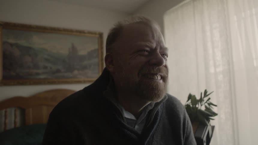 The man laughs as he watches something