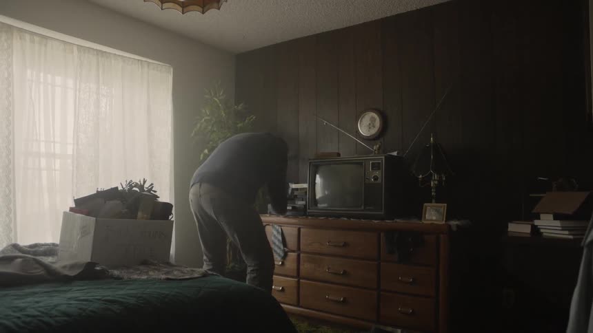 An elderly man puts a tape into a vcr