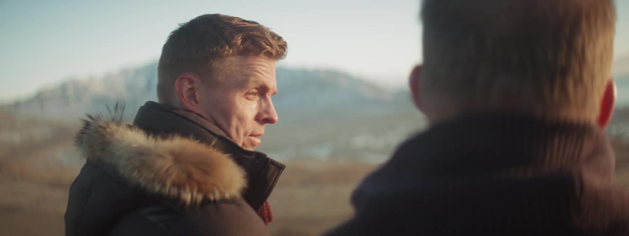 Two men look at the mountains together