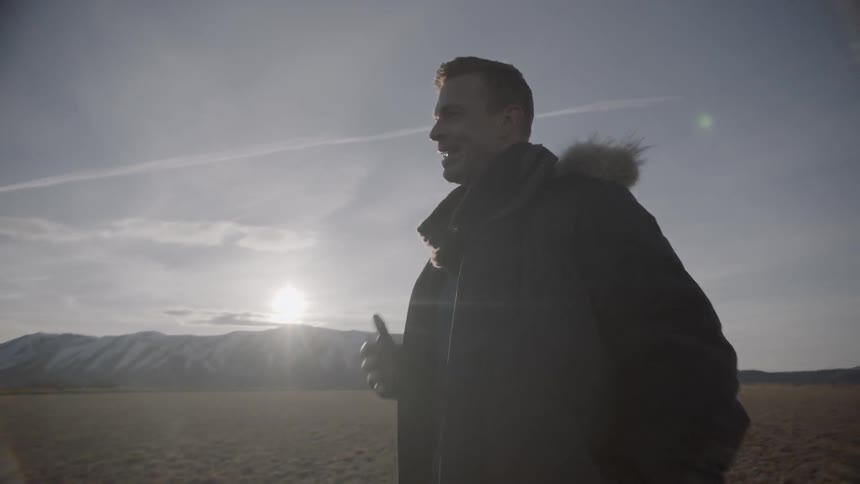 Two men stand in a rural field