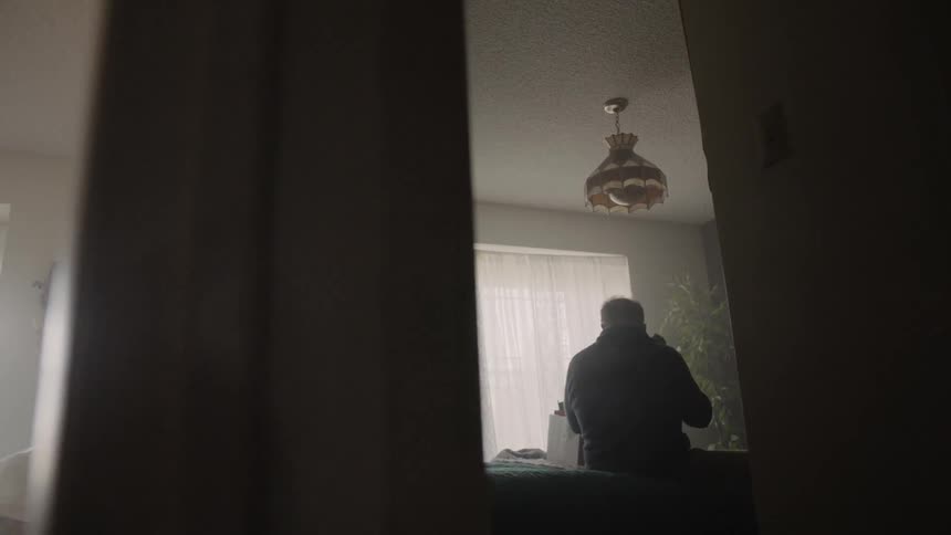 Man stands in a kitchen unpacking items out of a box