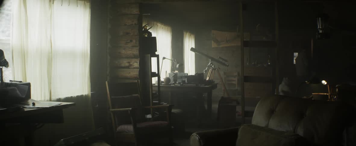 Man takes something down from the wall at his cabin