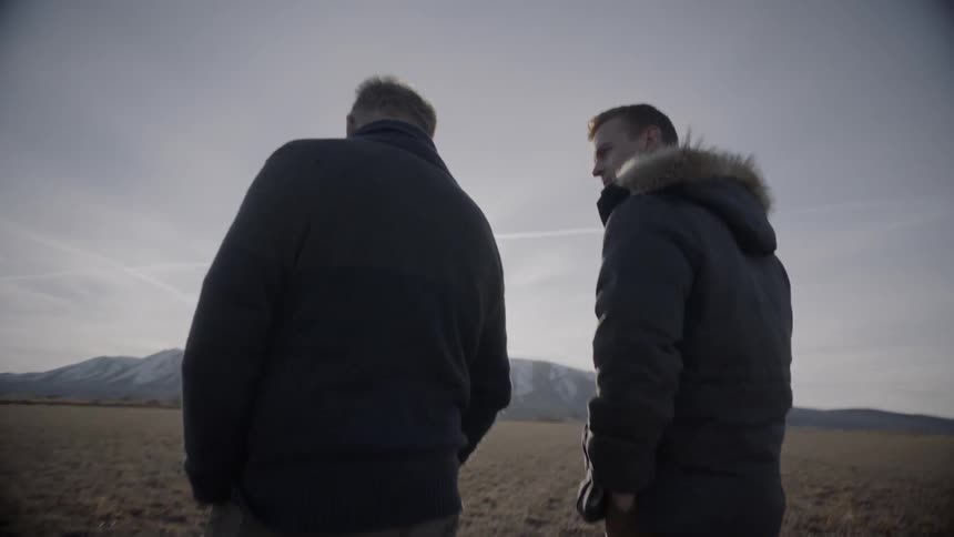 A man walks up to another and talks to him