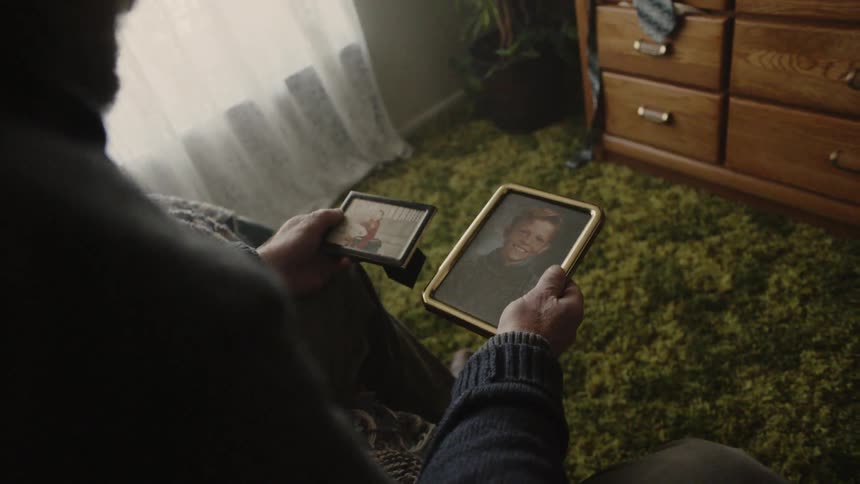 Man looks at framed photographs