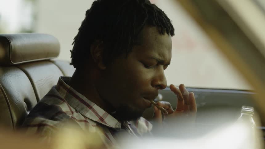 Man smokes while sitting in a parked car
