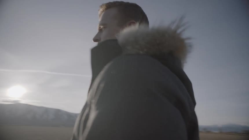 A man stands on the field before walking towards someone