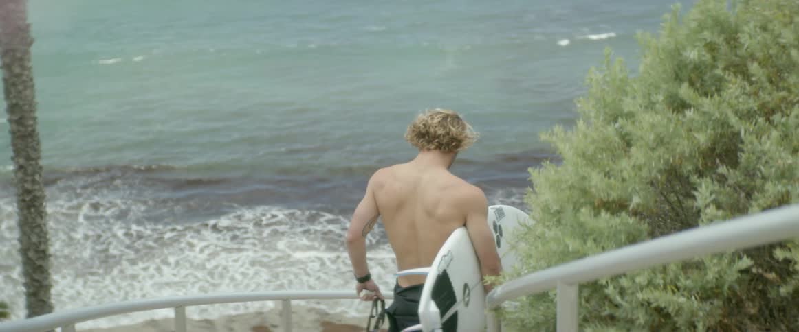 A man climbs down the steps towards the beach