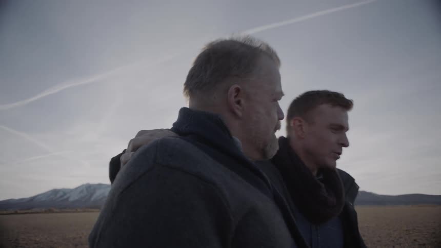 Two men walk in a rural field