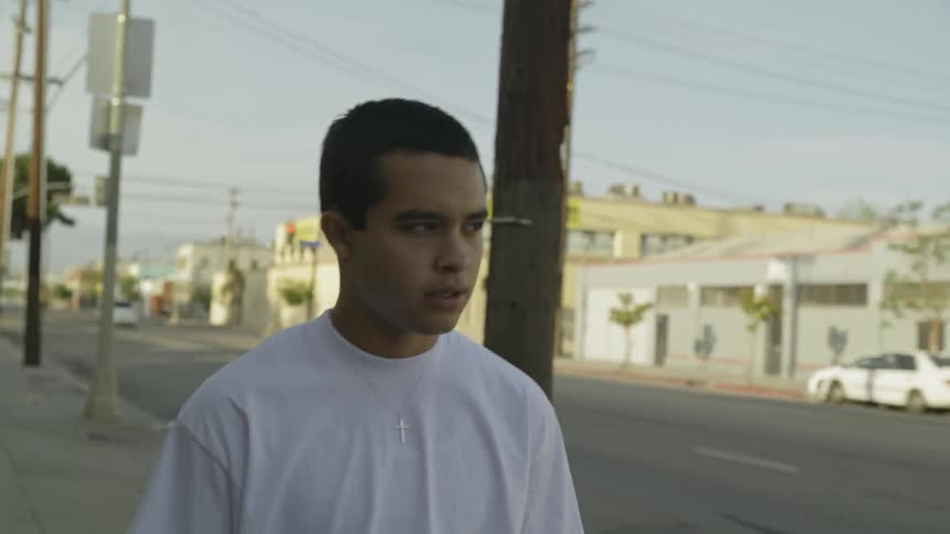 teenager walks on a city sidewalk