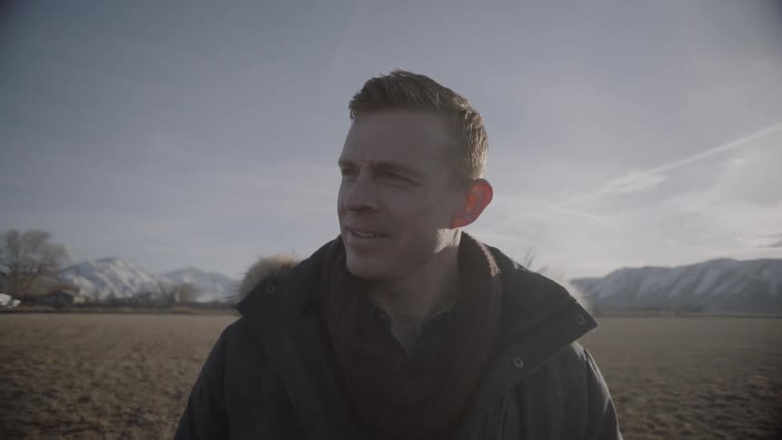A man smiles on the windy field