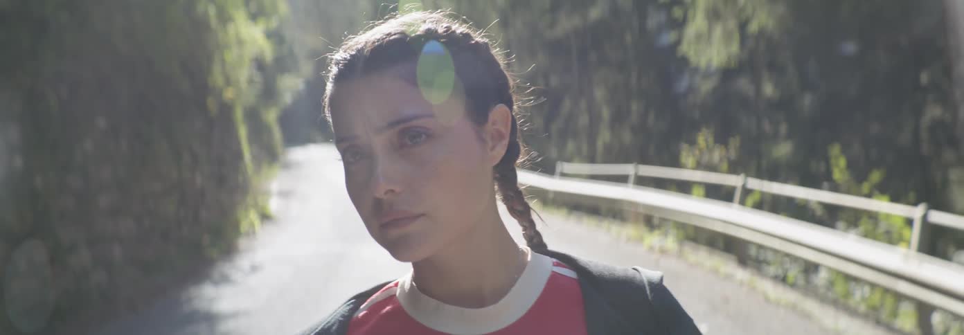 A cautious woman walks on a forest road