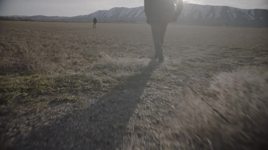 A man walks towards another standing in the distance