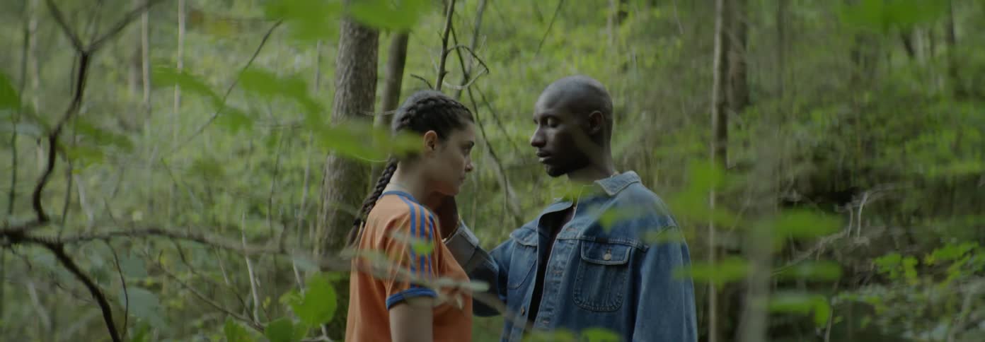 A man touches a woman's face near the tree