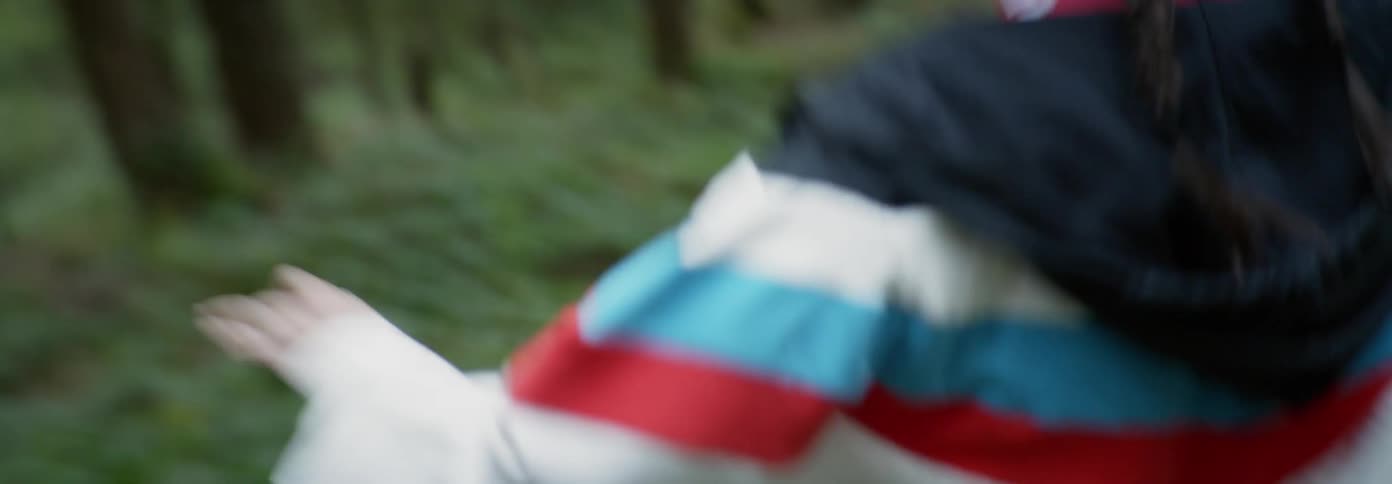 A woman is running from something into the woods