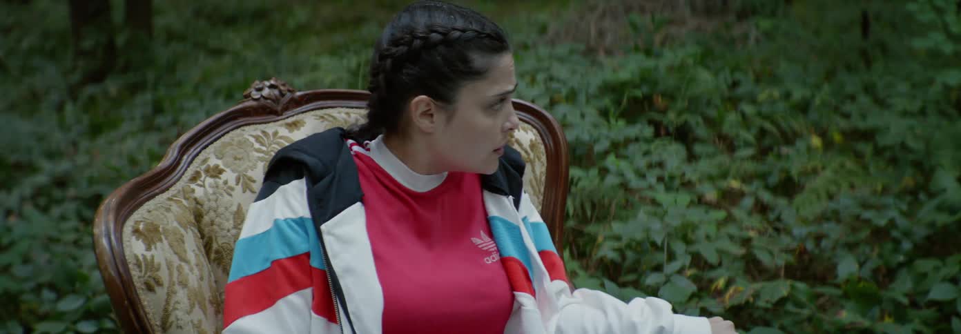 A woman searches around in fear from the chair