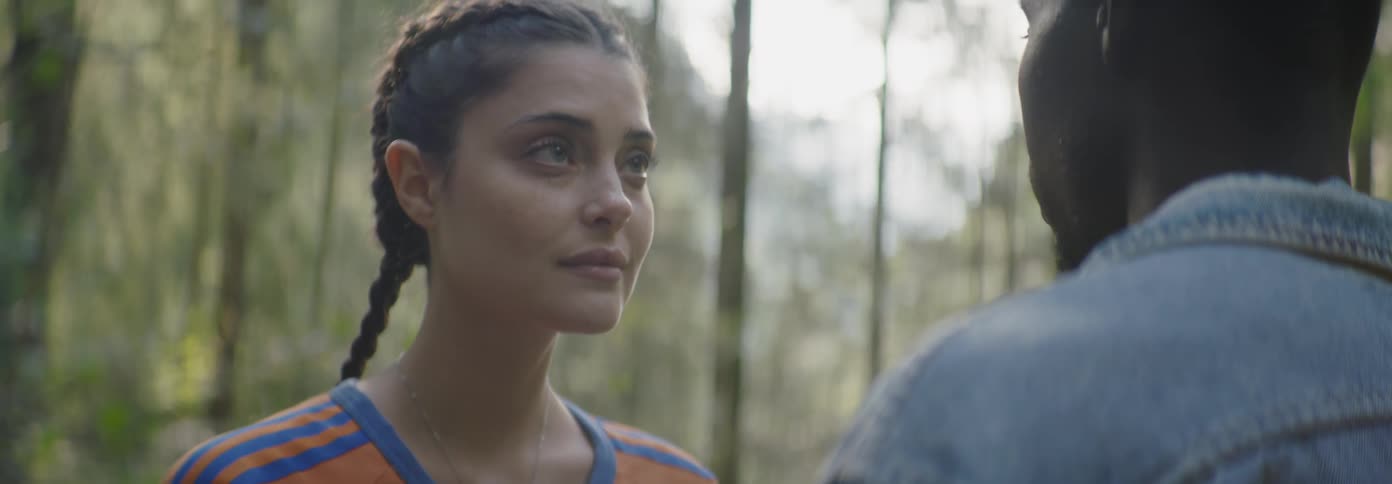 Man and woman look at each other in a forest