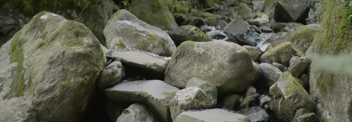 The large rocks sit before the stream