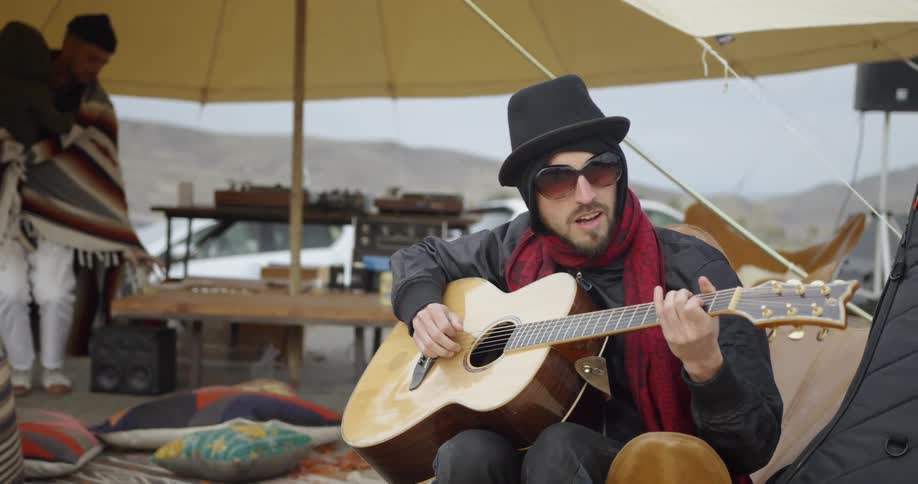 Man plays guitar at an outdoor market