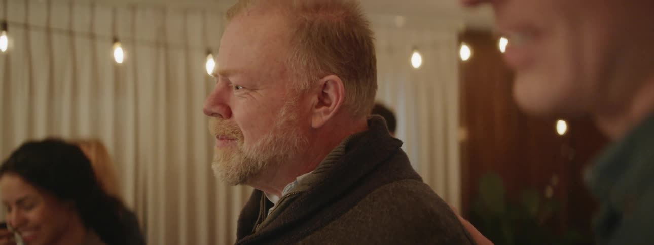 Man talks and smiles at a party