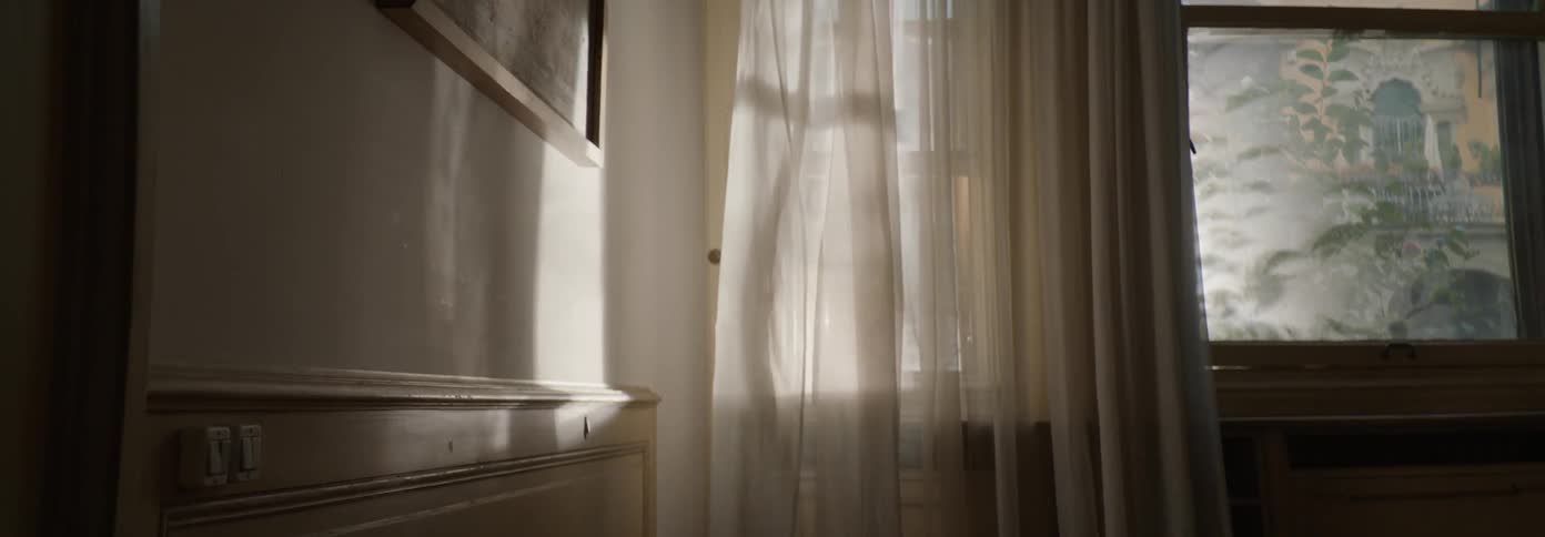 Wind blows through window curtains