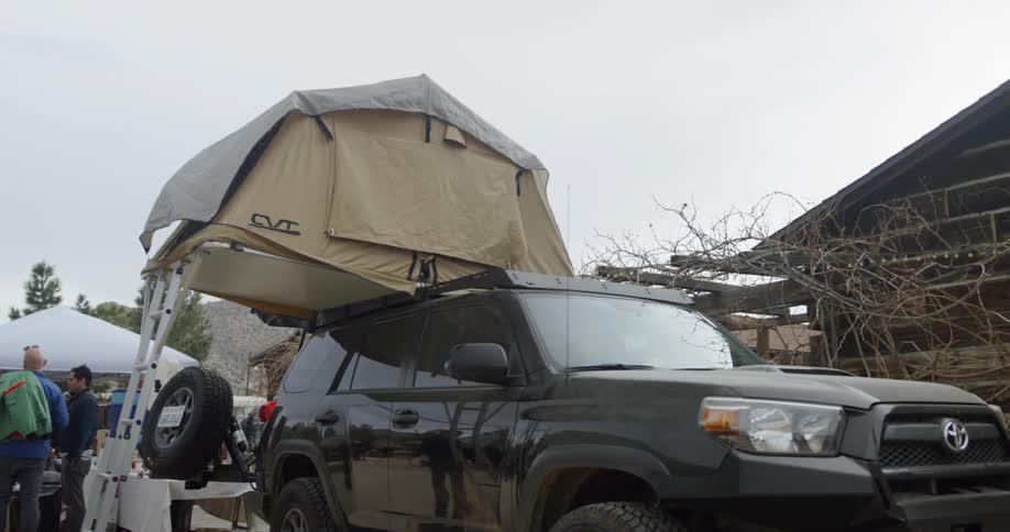 A tent is set up on top of a truck