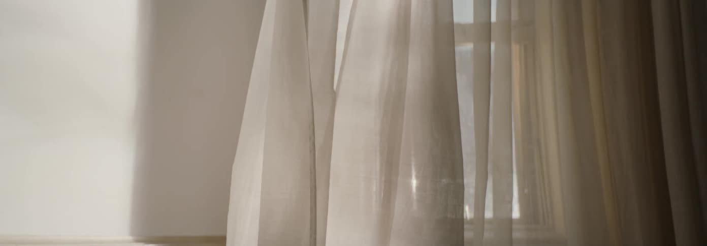 The wind is blowing the curtain in the room