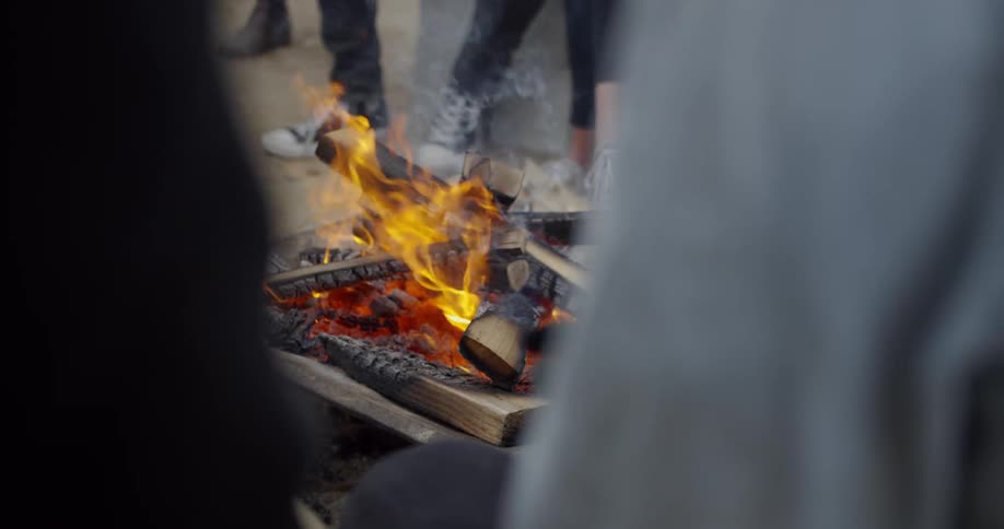 People stir the fire with sticks