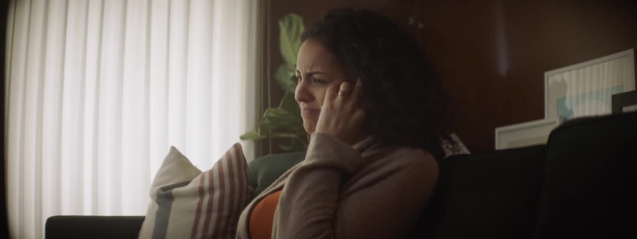 Woman talks on the phone while sitting on a couch