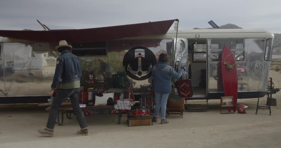 The people walk past the silver trailer
