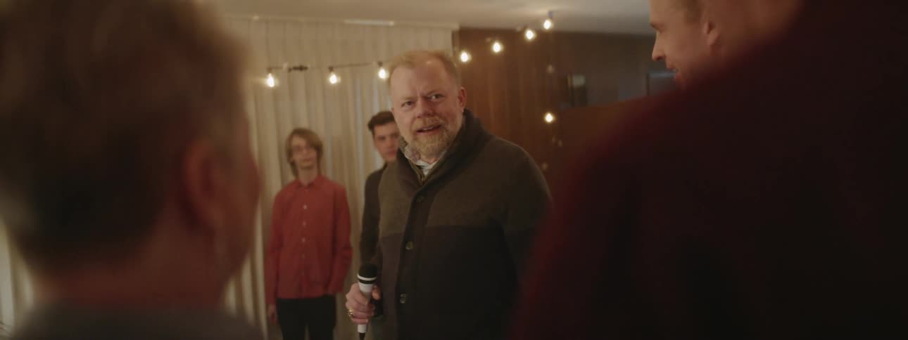 An older man is enjoying a party with friends in the evening