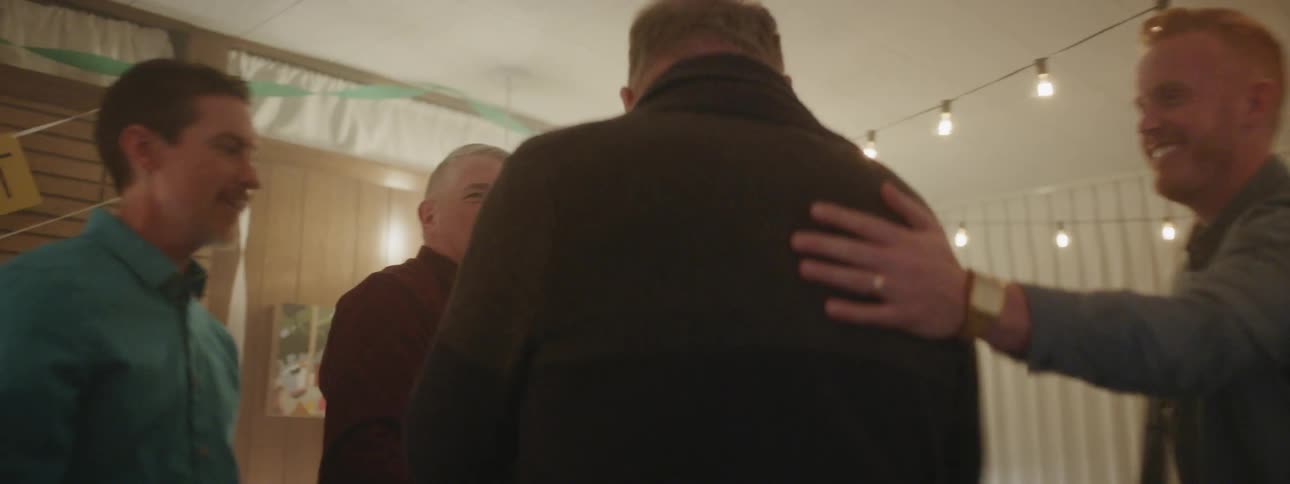 Two men shake hands at a celebration