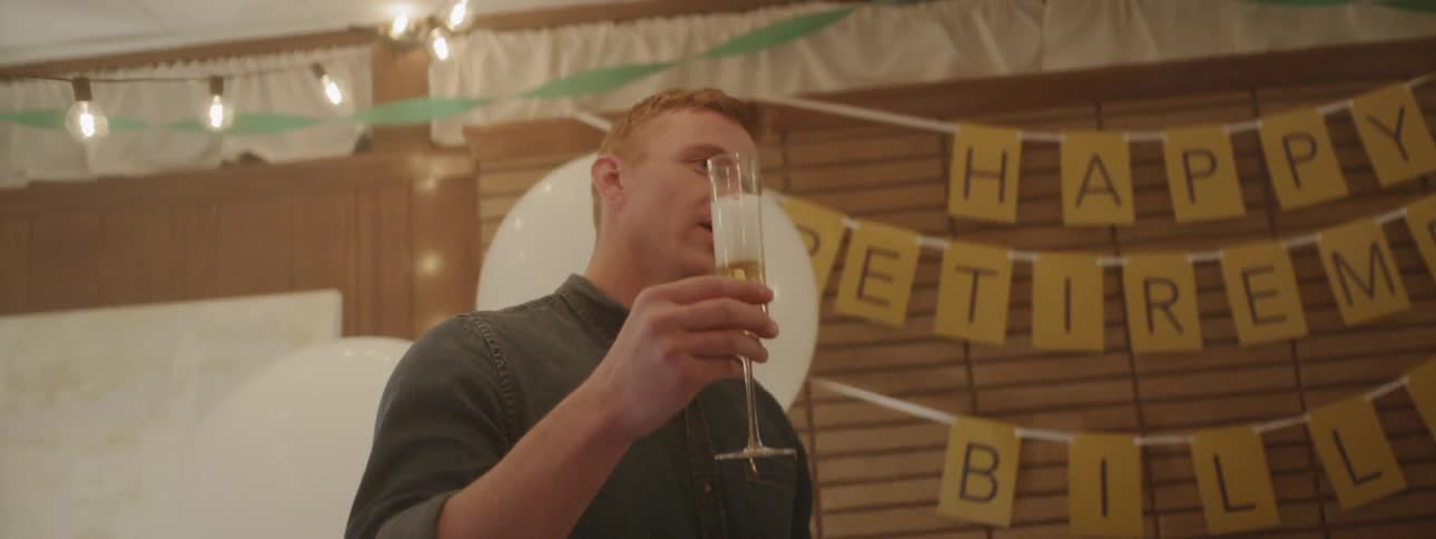 A man holds a drink while talking