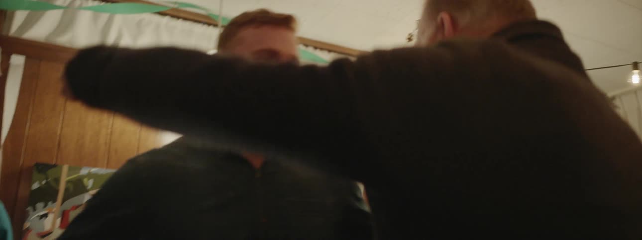 Two men hug and talk