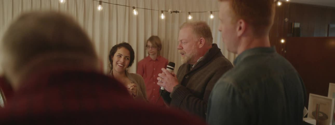 A man talks on the microphone at a party