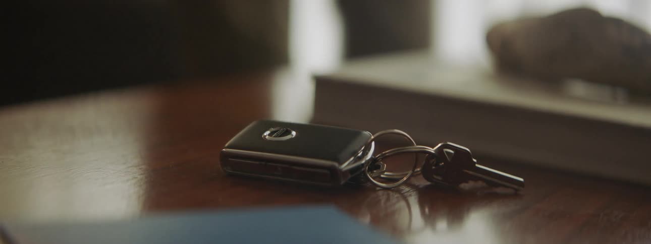 A hand grabs car keys from a table