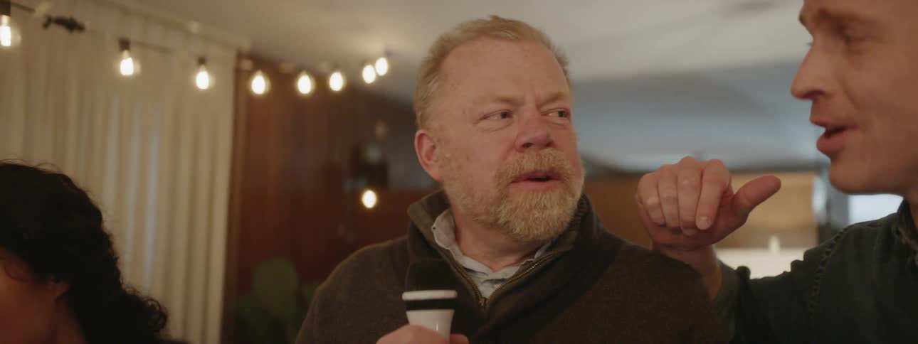 People sing karaoke at a house party