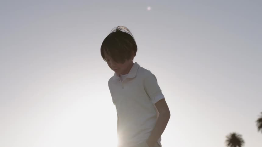 Boy walks outside at sunset