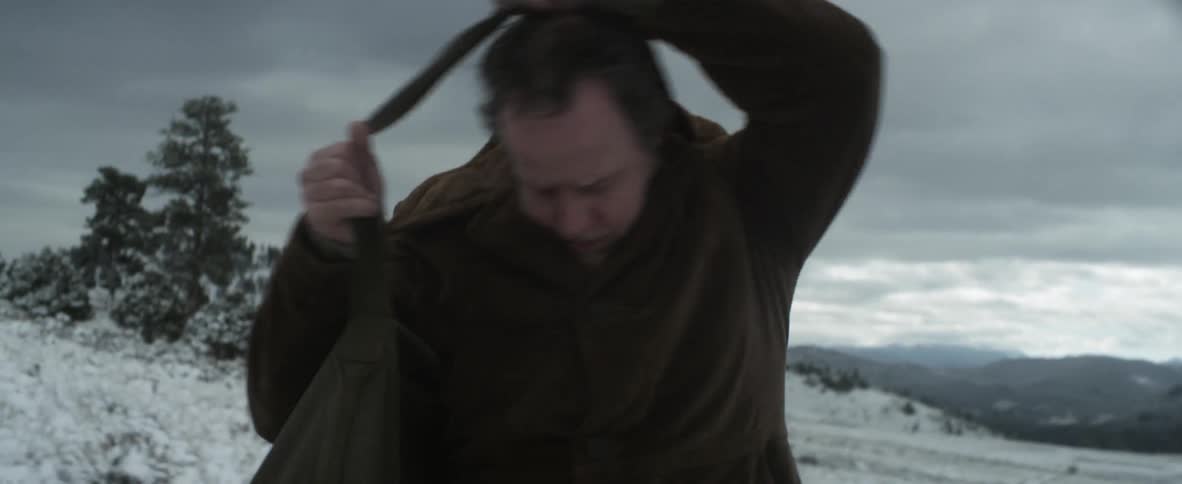 A man standing in a snowy field in the wilderness