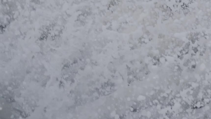 Waves crash through a beach pier